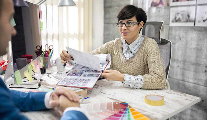 designer showing palette color to client in her studio